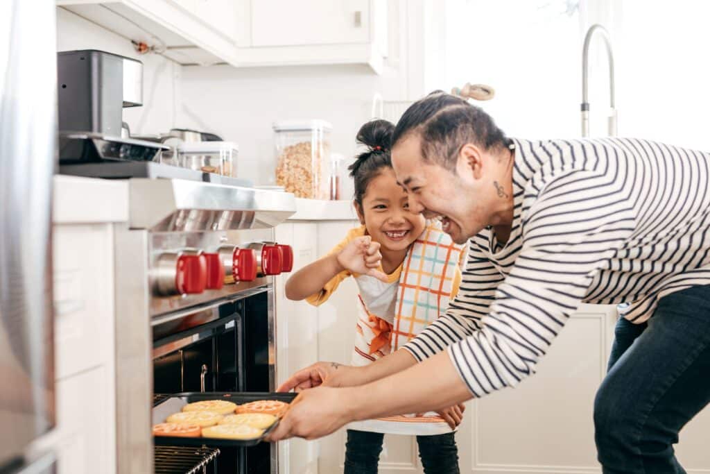 Family enjoying time together in a modern kitchen inside a Verge at Stillwater Edmonton townhome