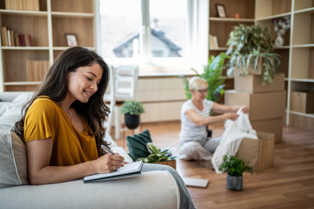 People organizing and settling into a bright living space inside a Cantiro home in Glenridding Ravine
