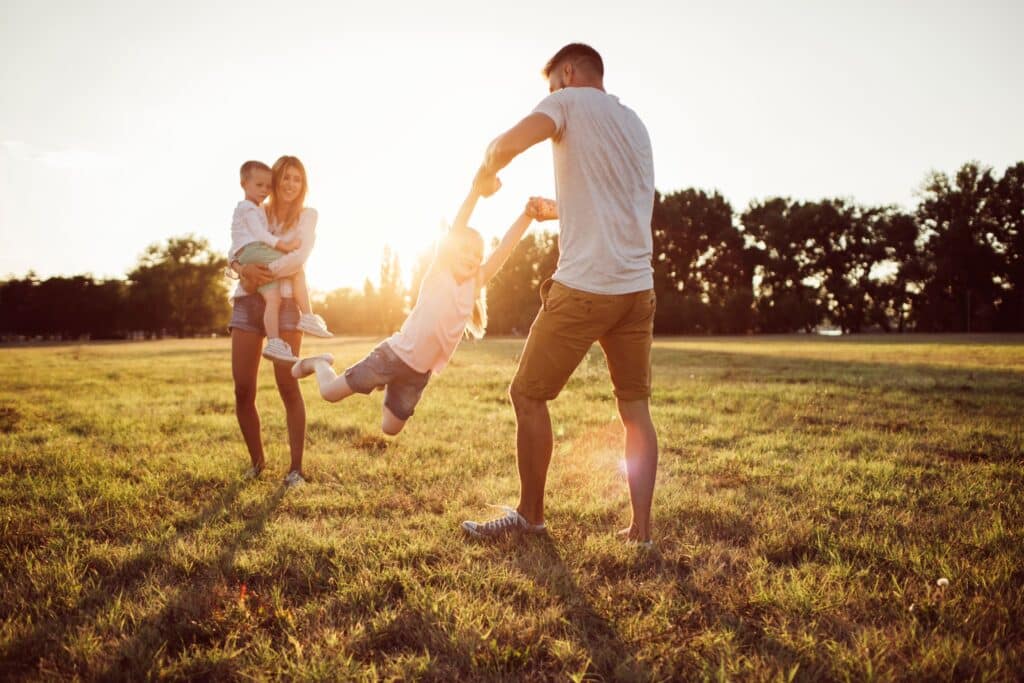 Two adults and two children spending time together outdoors at sunset, representing everyday family life near the Roseburn community in Fort Saskatchewan, Alberta.