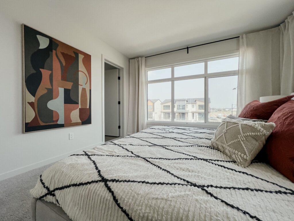 Spacious primary bedroom with contemporary decor and natural light in a Cantiro townhome.