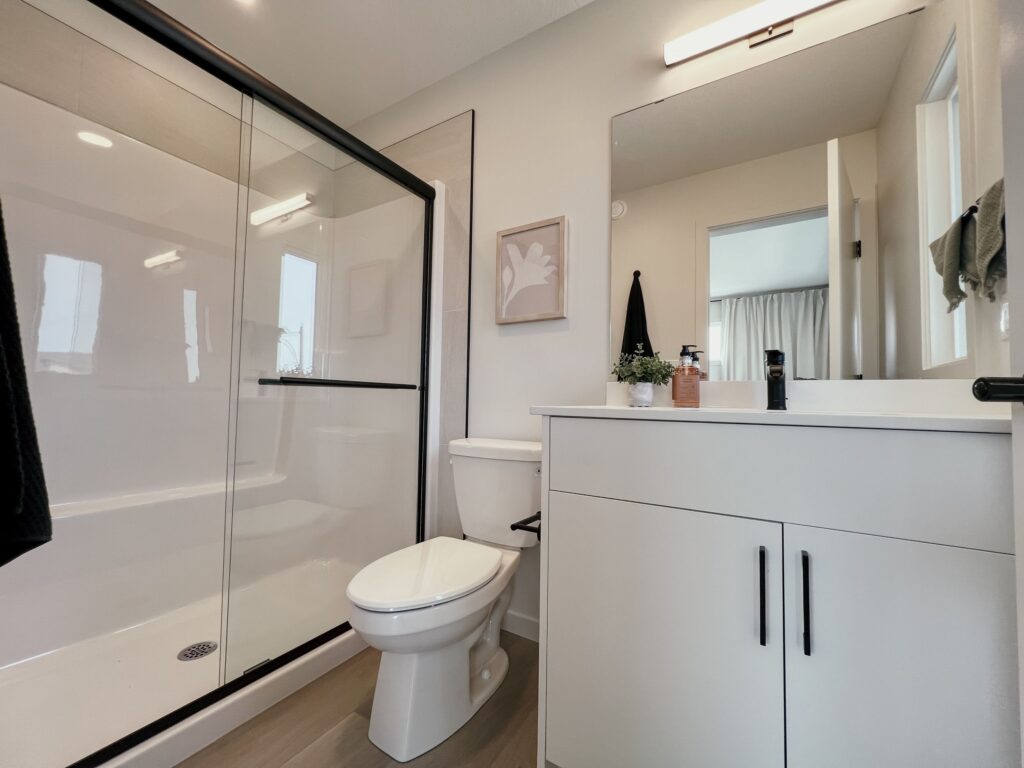 Modern bathroom with glass‑enclosed shower and vanity in a Cantiro townhome.