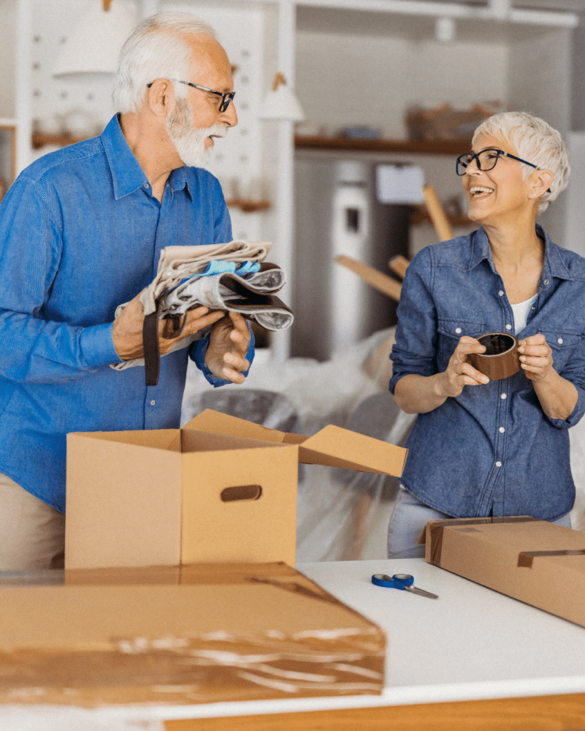 Seniors packing belongings into boxes during the downsizing process at home in Edmonton